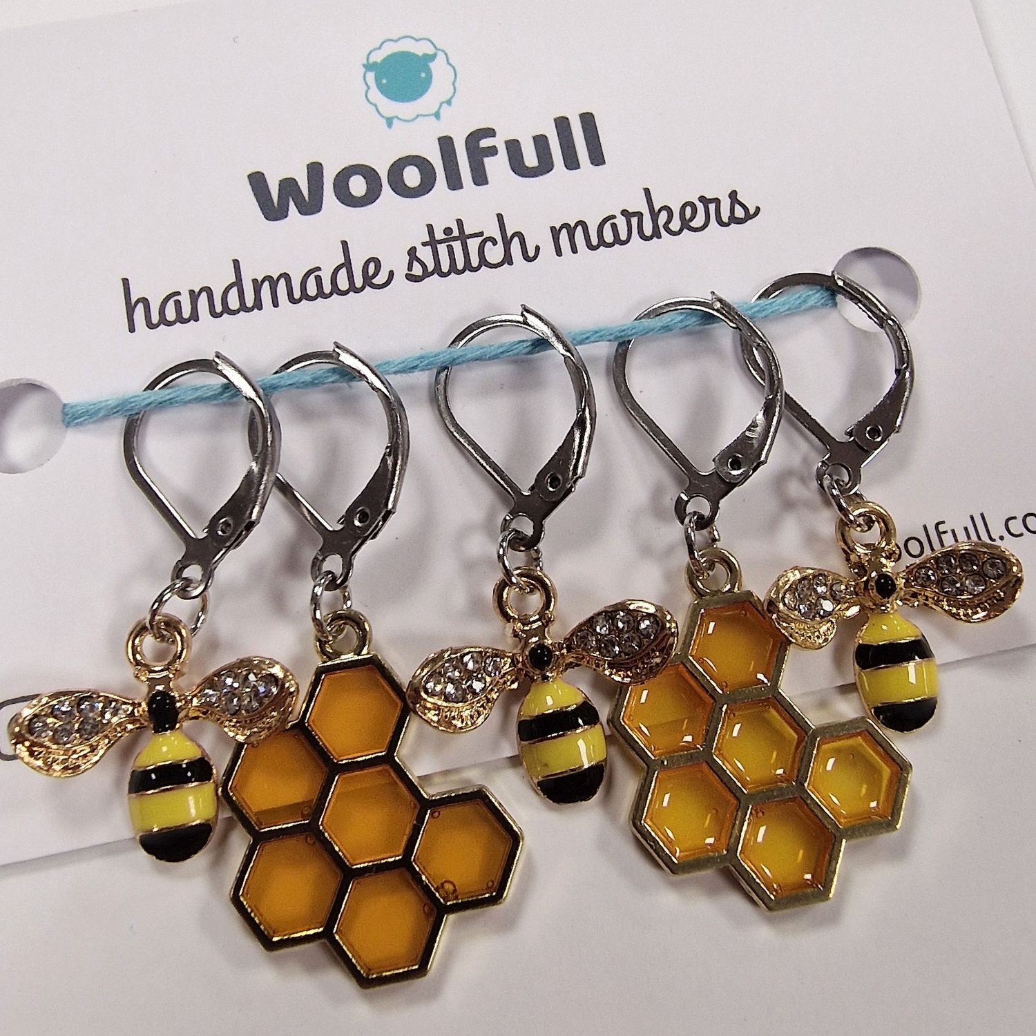 3 metal bee stitch markers and 2 resin honeycomb stitch markers.