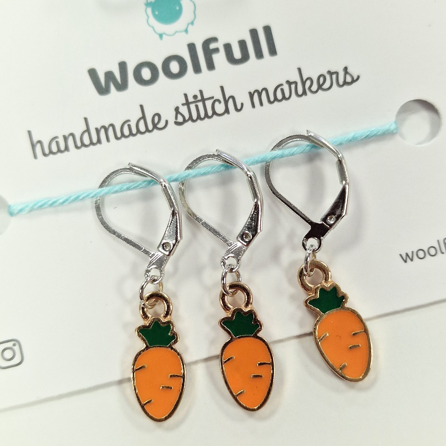 3 carrot shaped stitch markers.

