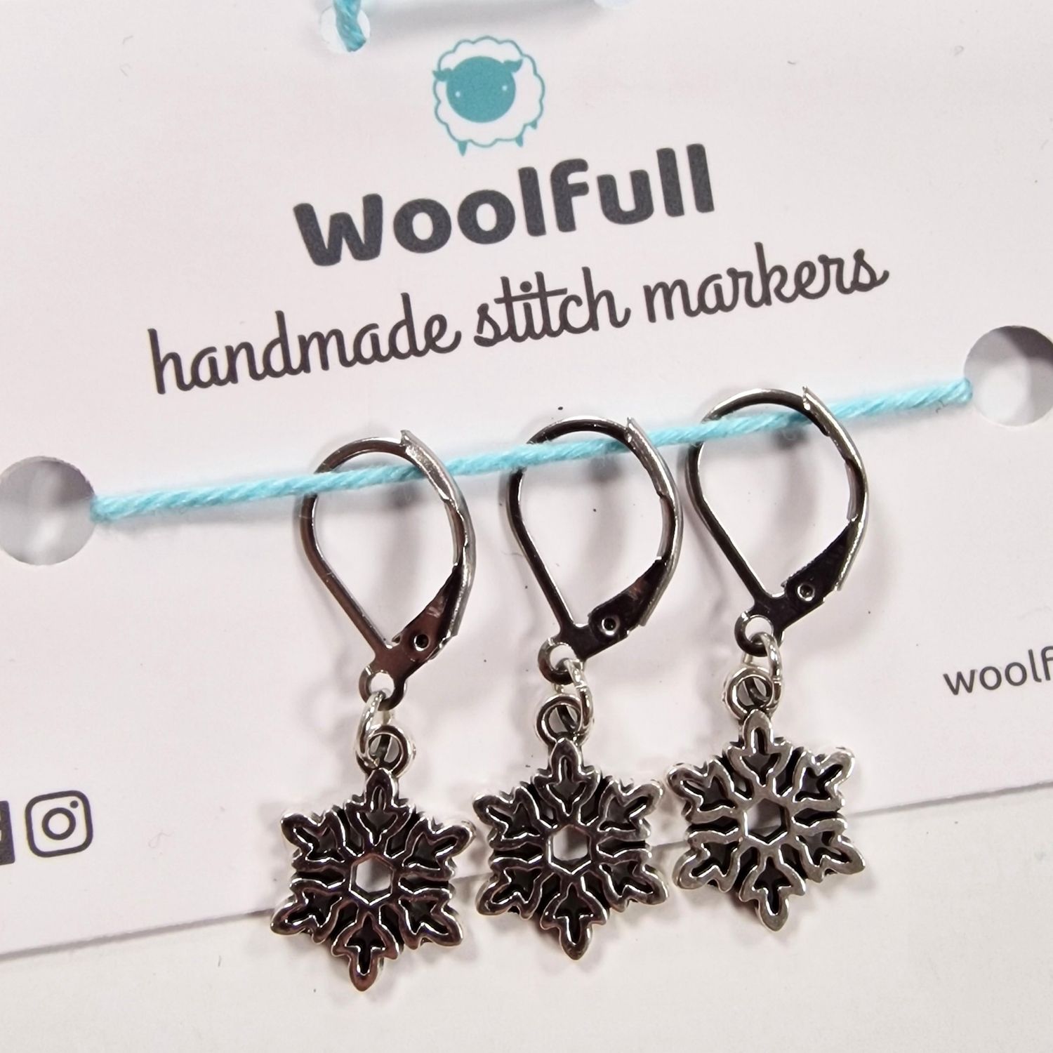 3 snowflake shaped stitch markers.