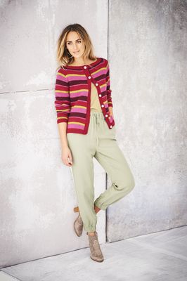 A woman is wearing a pink, red, yellow and burgundy stripy knitted cardigan.