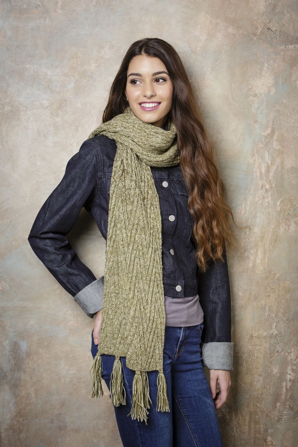 A woman is wearing an olive green knitted scarf.