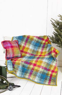 A crocheted blanket made up of small colourful squares, in a layout designed to mimic tartan.