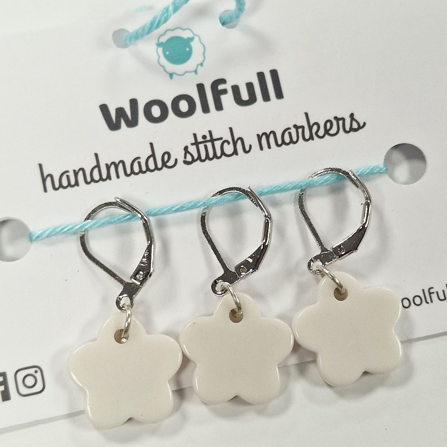 3 white flower stitch markers.