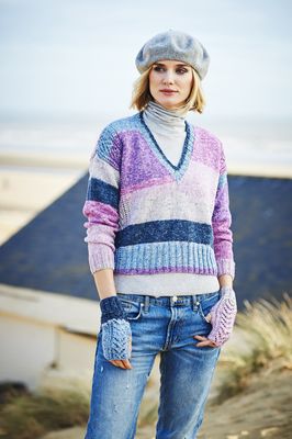 A woman is wearing a knitted sweater in a variegated pink, blue and purple yarn.