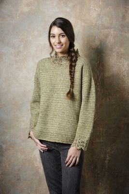 A woman is wearing an olive green crocheted sweater.