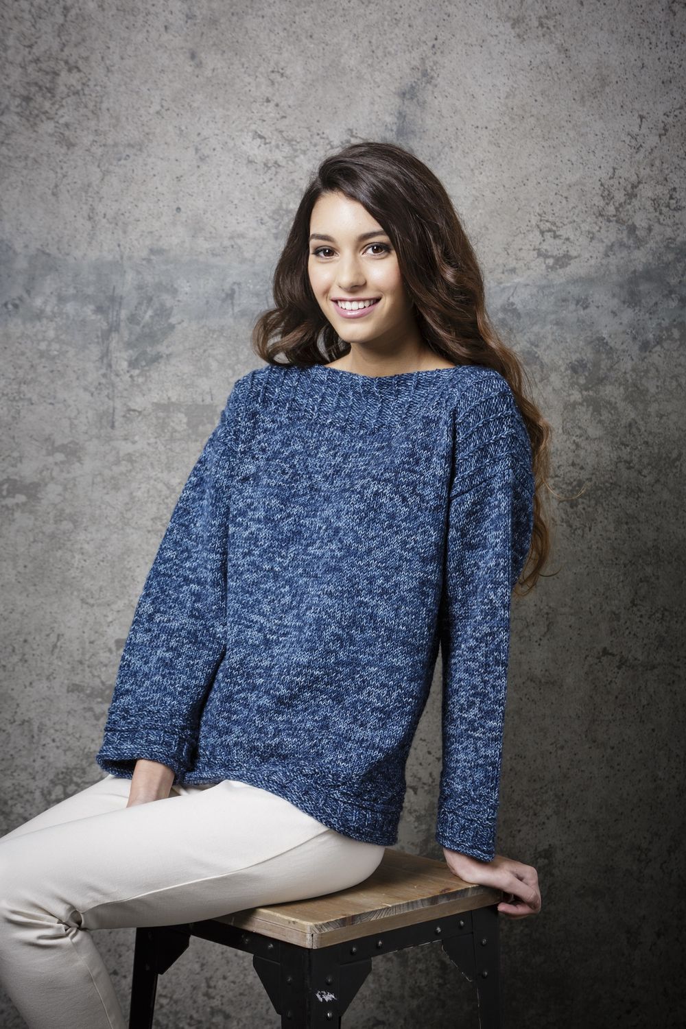 A girl is wearing a dark blue knitted sweater.