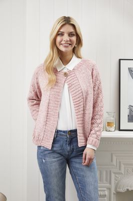 A woman is wearing a light pink knitted cardigan.