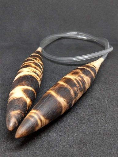 A pair of wooden circular knitting needles with a burnt wood design.