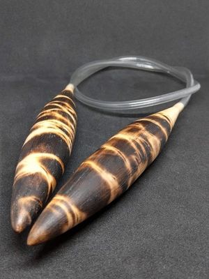 A pair of wooden circular knitting needles with a burnt wood design.