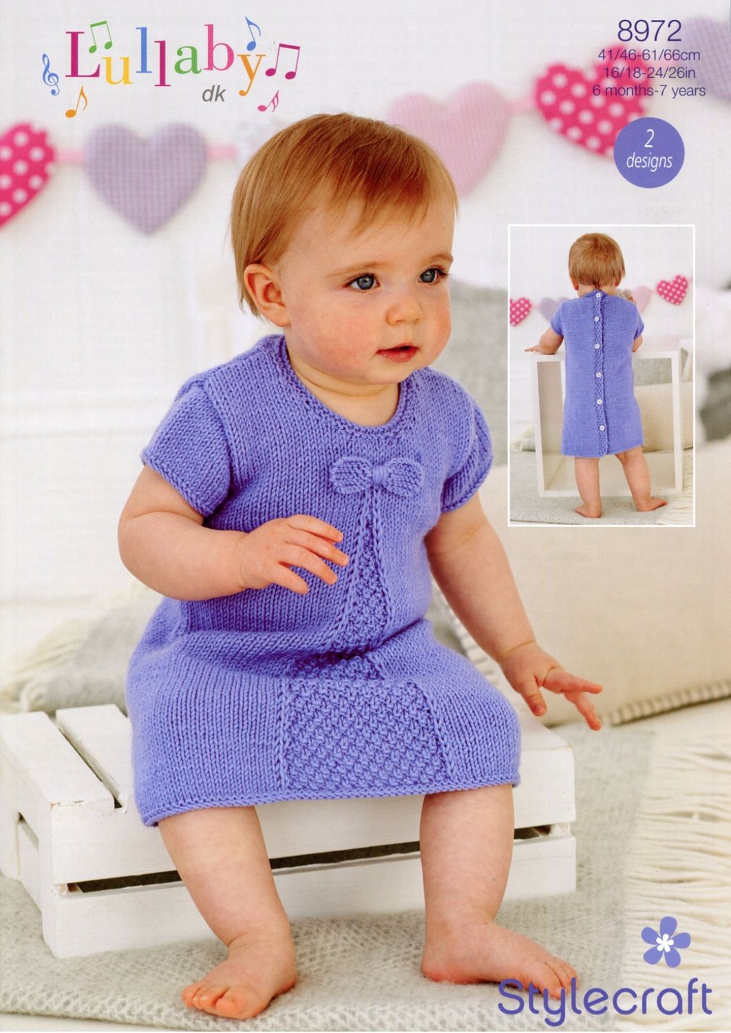 A baby is wearing a purple knitted dress.