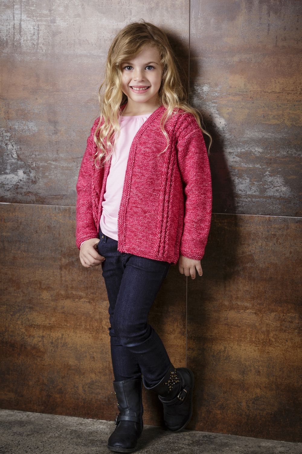 A girl is wearing a dark pink knitted cardigan.