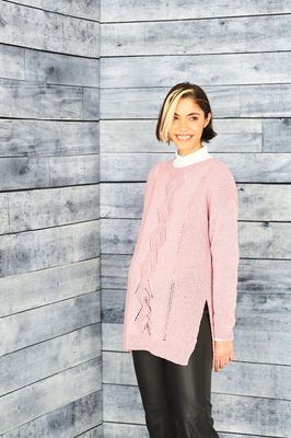 A woman is wearing a pale pink yellow knitted tunic.