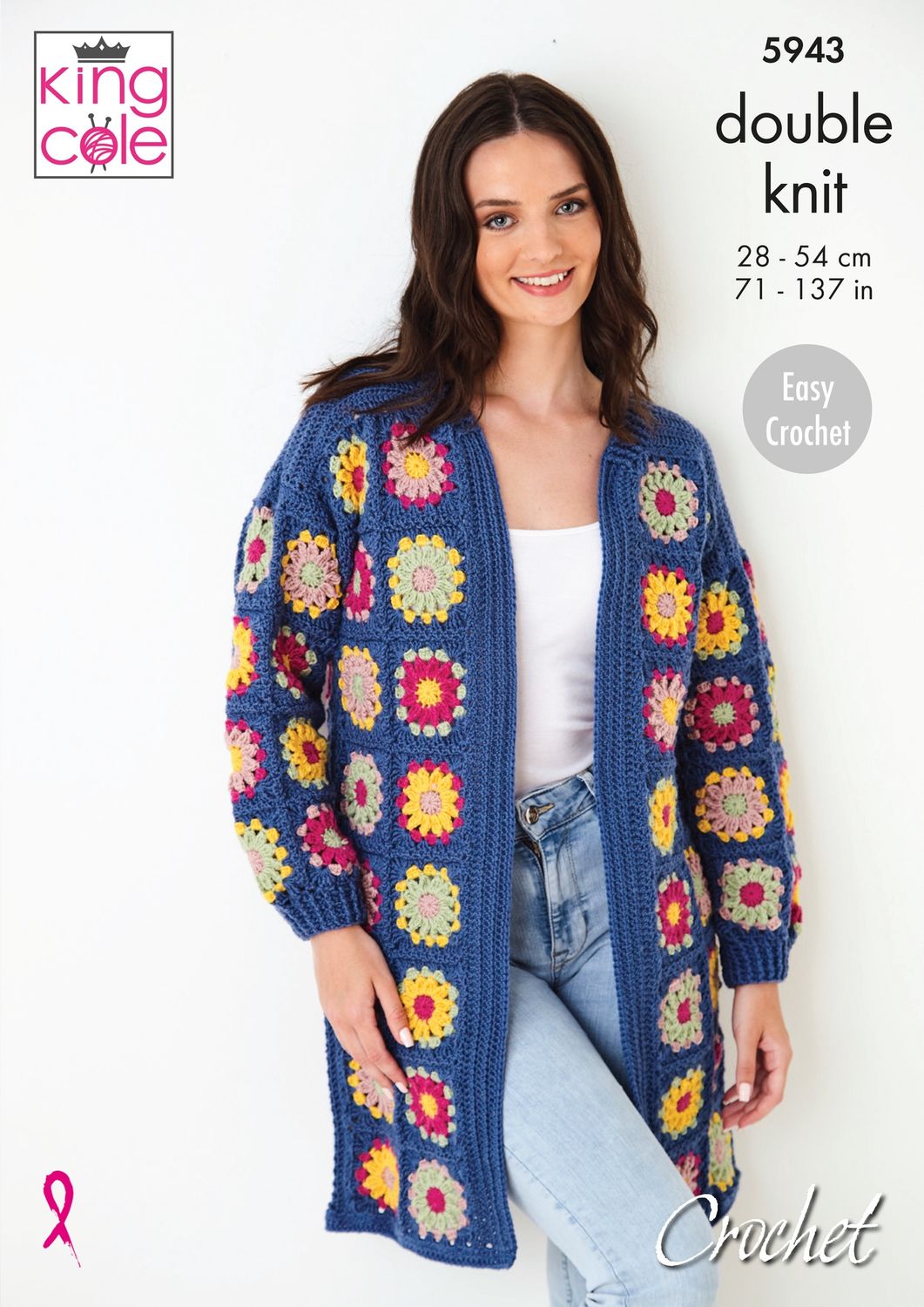 A woman is wearing a long crocheted cardigan, made of multicoloured granny squares that are all bordered and joined in dark blue.