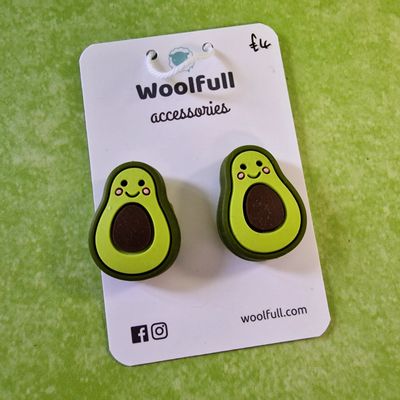 A green background with a pair of avocado shaped point protectors mounted on a white card.