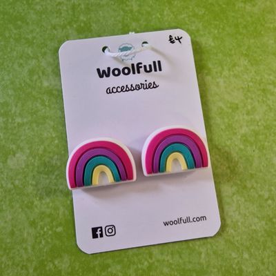 A green background with a pair of rainbow shaped point protectors mounted on a white card.
