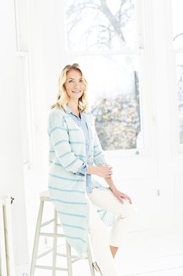A woman is wearing a light blue knitted cardigan with darker blue stripes.