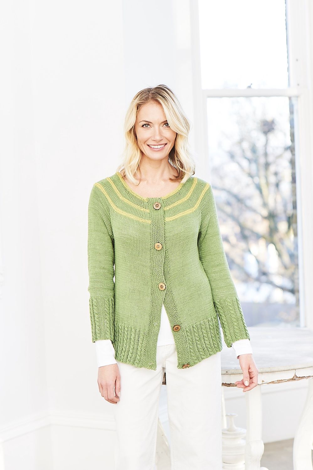 A woman is wearing a green knitted cardigan.