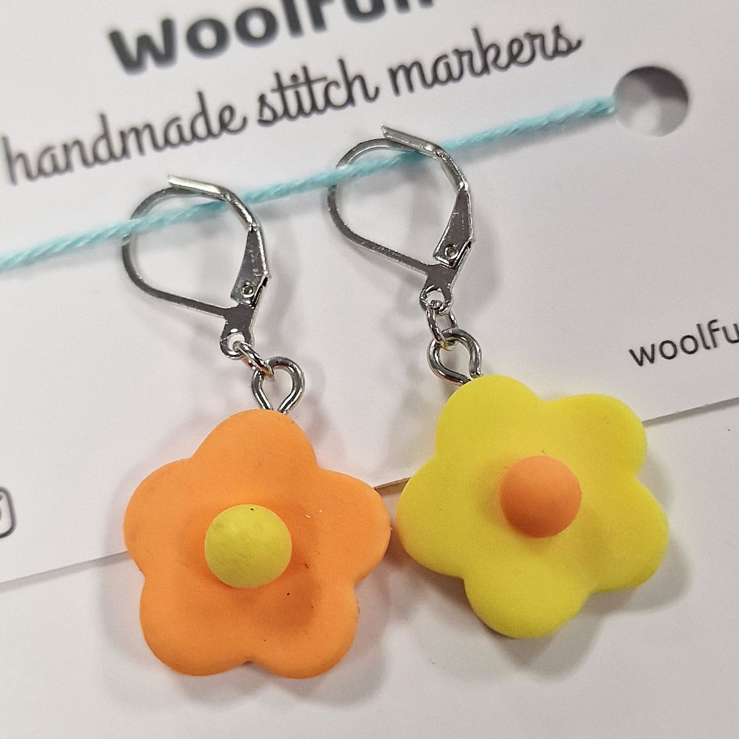 2 flower shaped stitch markers, 1 orange and 1 yellow.

