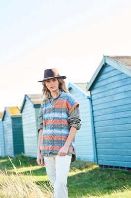 A woman is wearing a knitted tank top in shades of blue and orange.