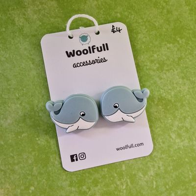 A green background with a pair of whale shaped point protectors mounted on a white card.