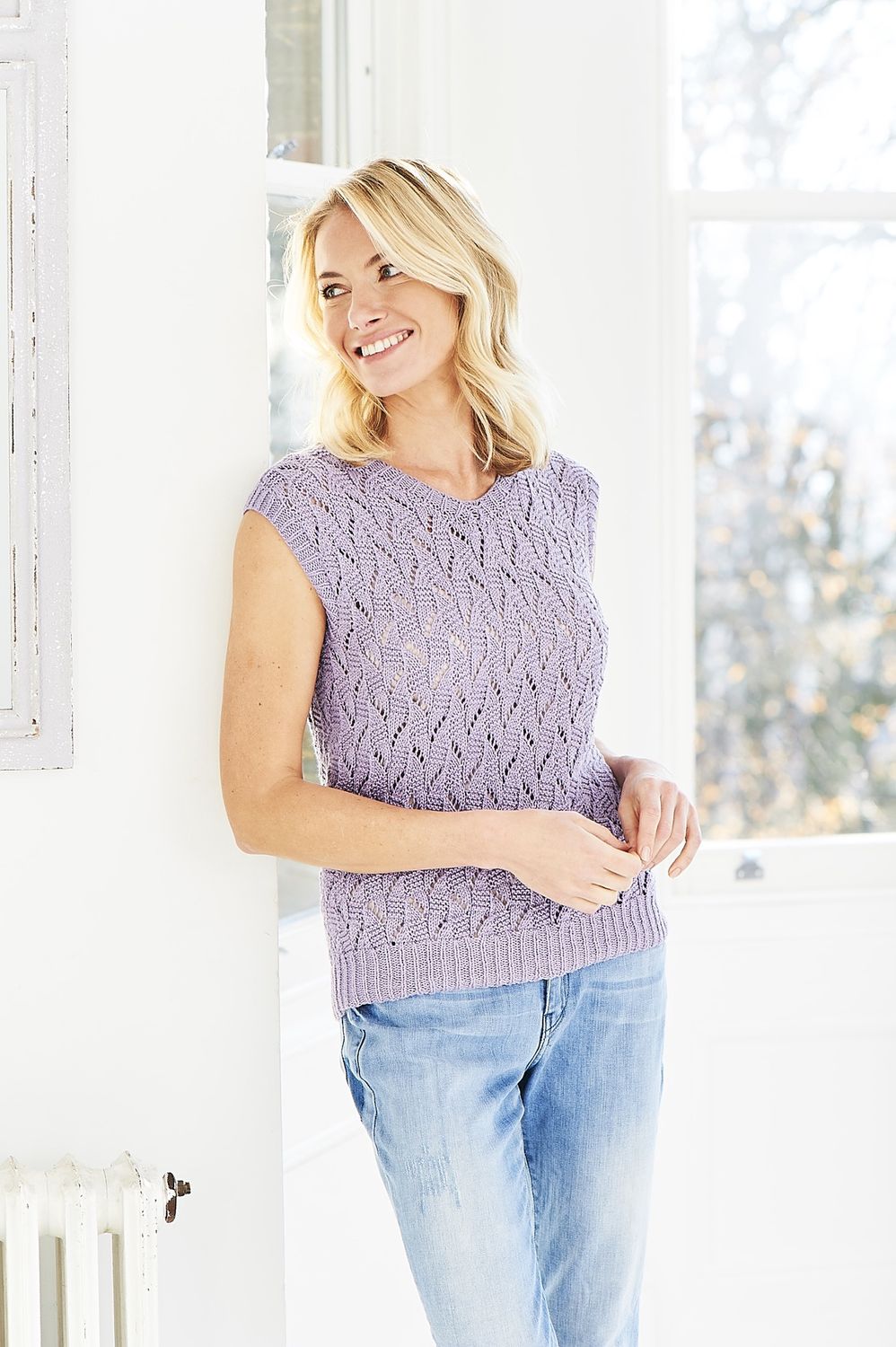A woman is wearing a light purple knitted lace top.