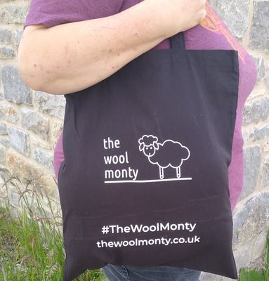 A black tote bag with &#39;The Wool Monty&#39; logo in the centre.