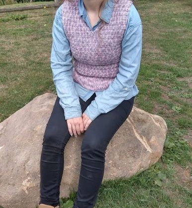 Rosie is wearing a crocheted tank top in a variegated pink yarn.