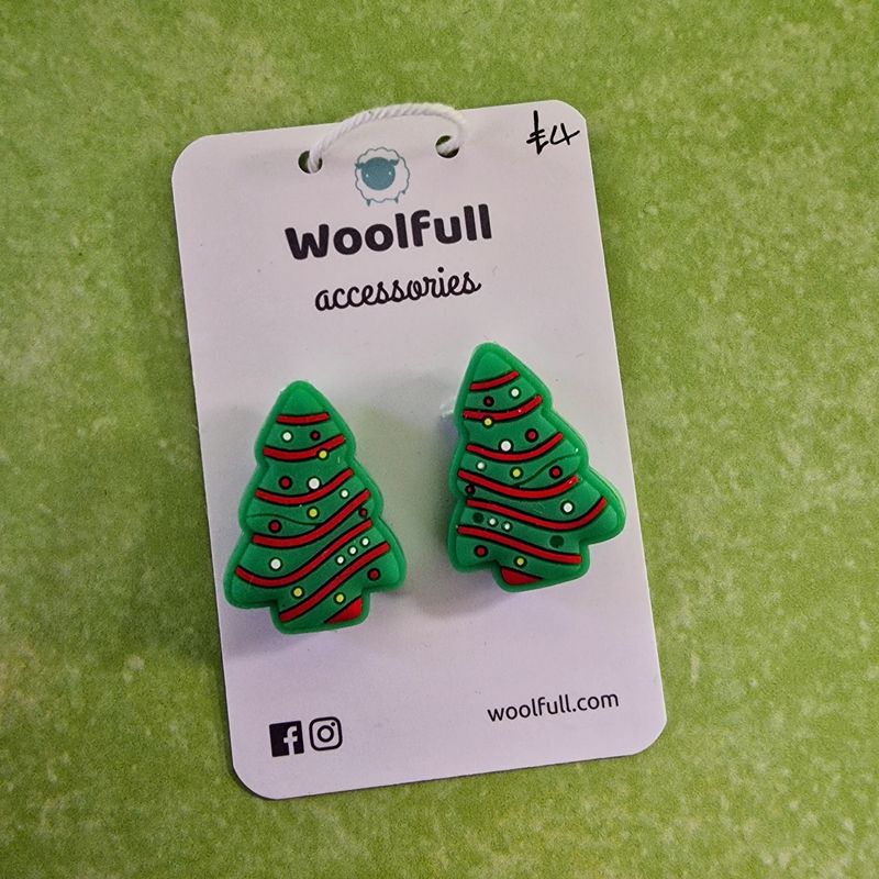 A green background with a pair of Christmas tree shaped point protectors mounted on a white card.