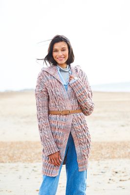 A woman is wearing a knitted jacket in shades of blue and brown.