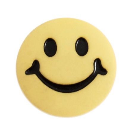 A round yellow button with a printed smiley face.