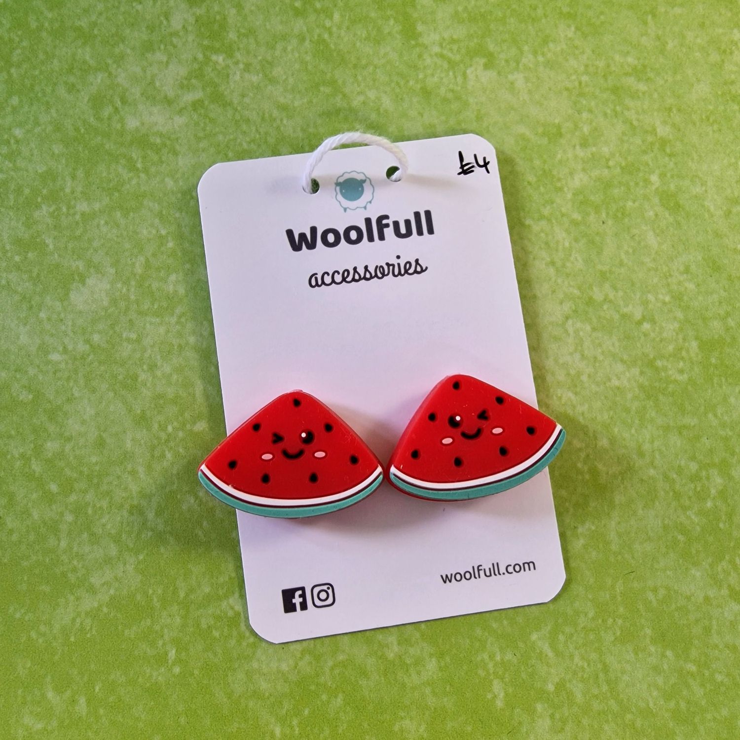 A green background with a pair of watermelon shaped point protectors mounted on a white card.