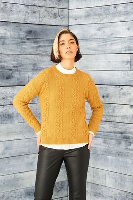 A woman is wearing a mustard yellow knitted sweater.