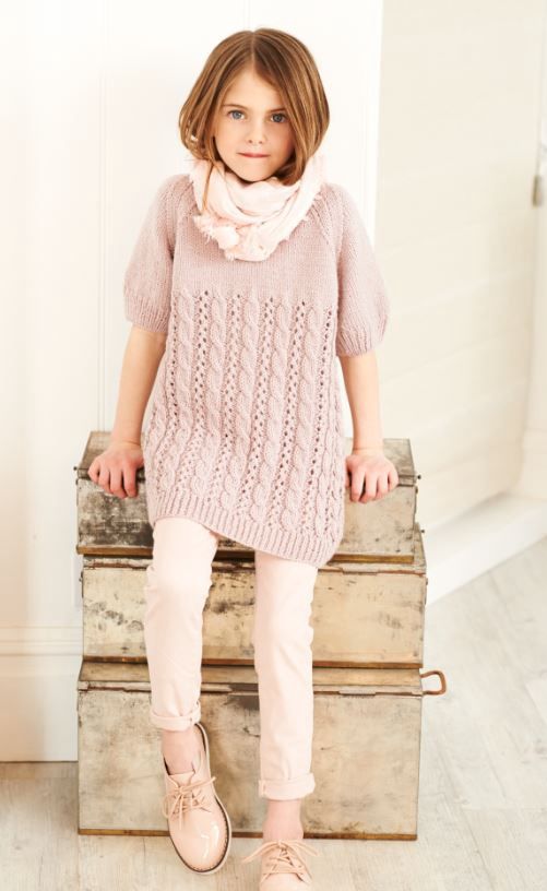 A girl is wearing a pink knitted tunic