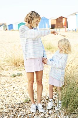 A woman and a girl are wearing matching knitted sweaters in a variegated pale purple and blue yarn.