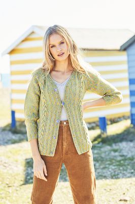 A woman is wearing a green cable knit cardigan.