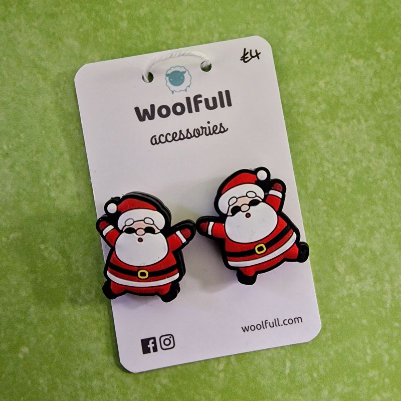 A green background with a pair of Santa shaped point protectors mounted on a white card.