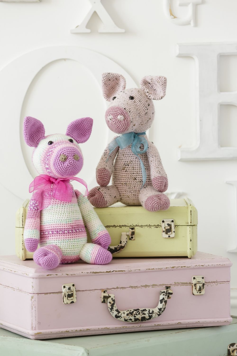 2 crocheted pigs in various shades of pink.