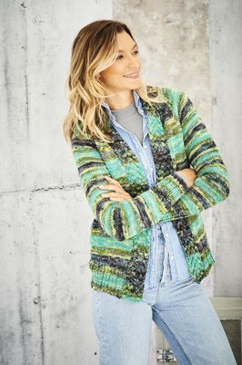 A woman is wearing a knitted cardigan in a variegated green yarn.