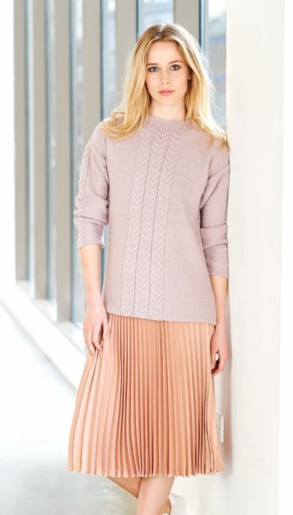 A woman is wearing a pink knitted sweater.