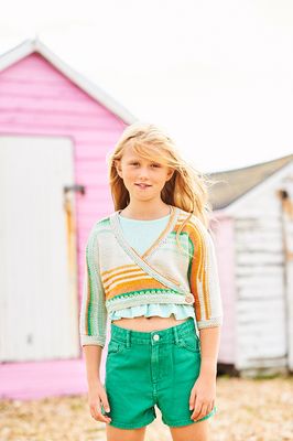 A girl is wearing a knitted ballet top in shades of cream, green and orange.