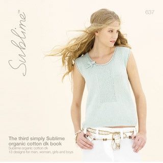 A woman is wearing a pale blue knitted top.