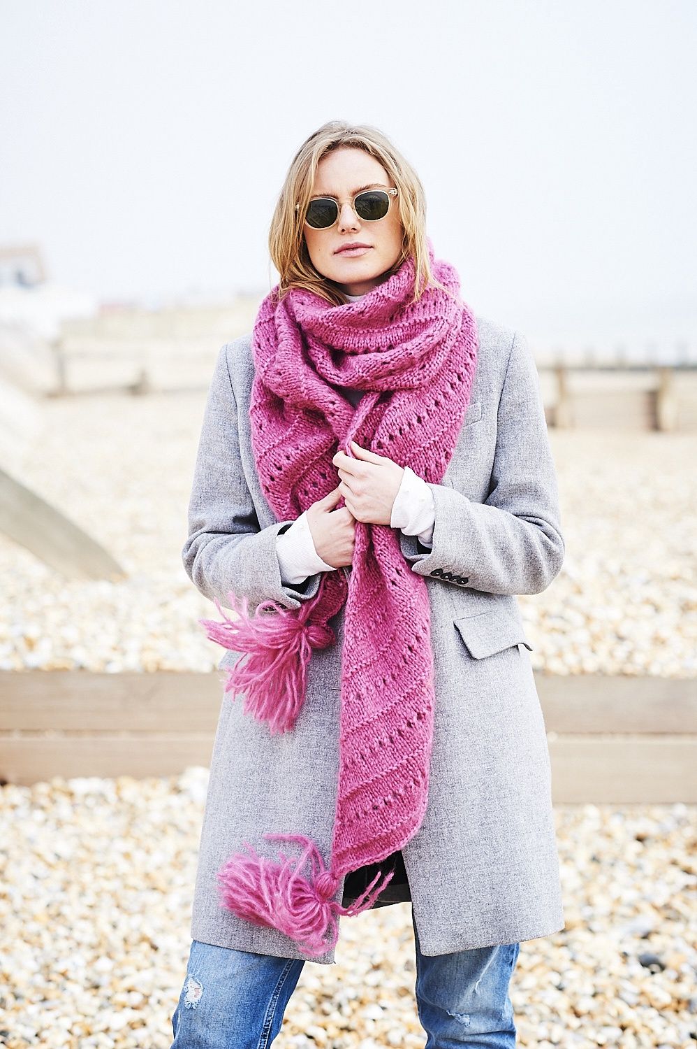 A woman is wearing a pink knitted shawl.