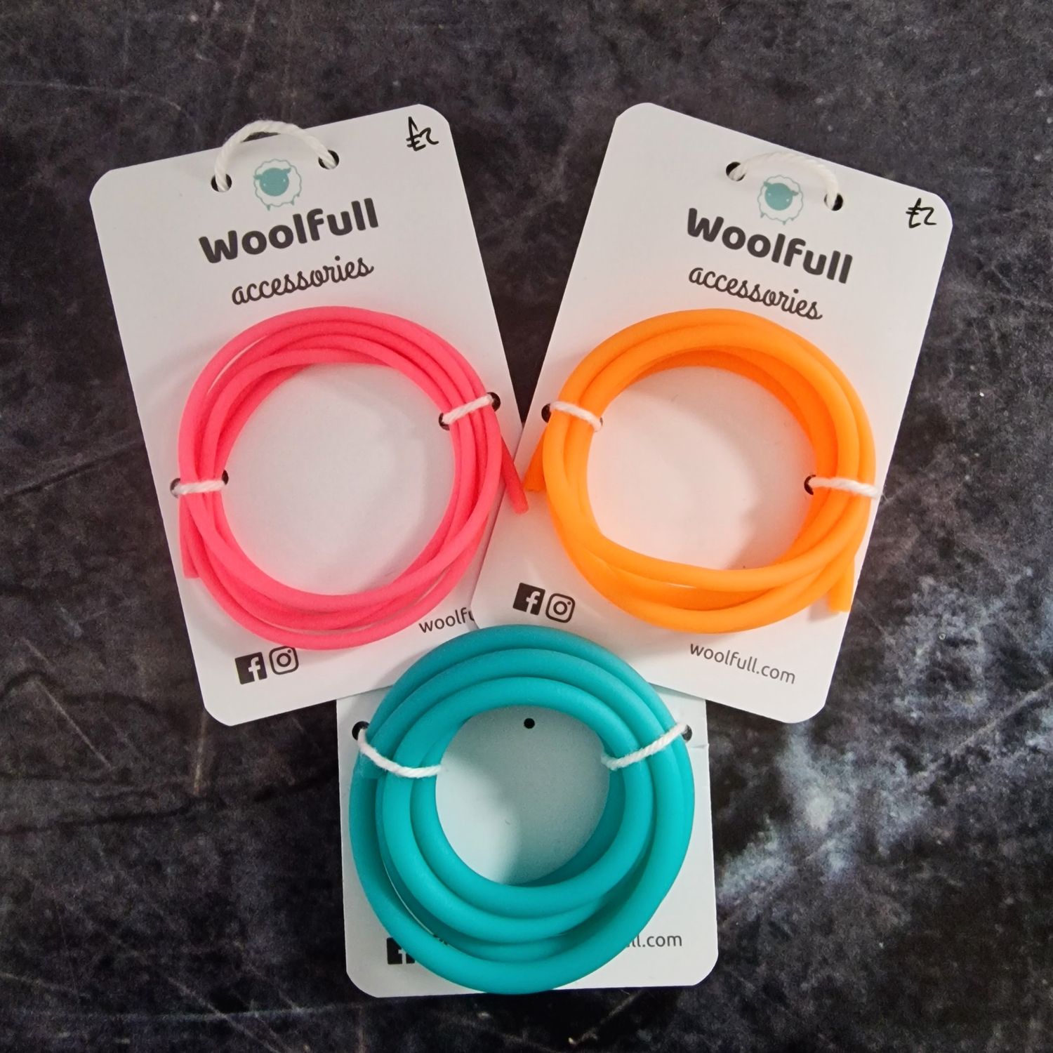 A photo of a 3 different sizes of stitch holder cables mounted on cards.