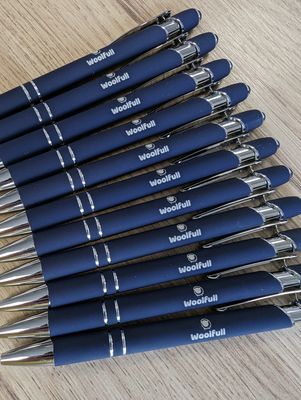 A bundle of Woolfull pens on a wooden background.