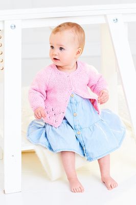 A baby is wearing a knitted pink cardigan.