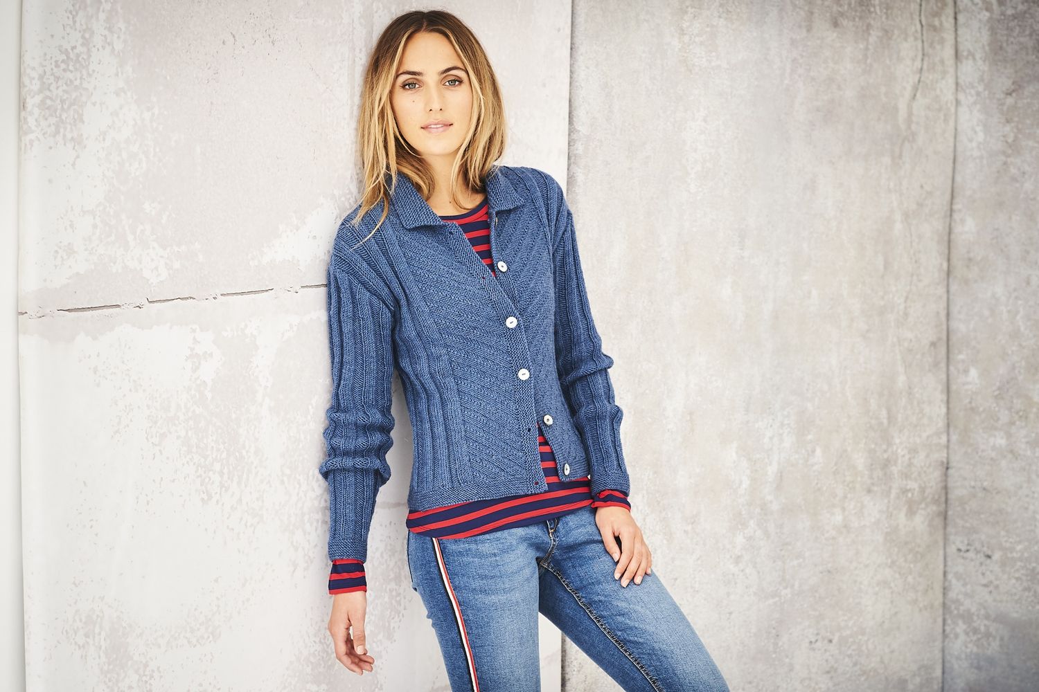 A woman is wearing a dark blue knitted cardigan.