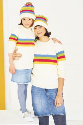 A woman and a girl are wearing matching white knitted sweaters and hats with blue, green, red and yellow stripes.