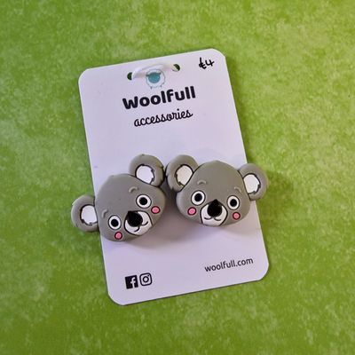 A green background with a pair of koala shaped point protectors mounted on a white card.