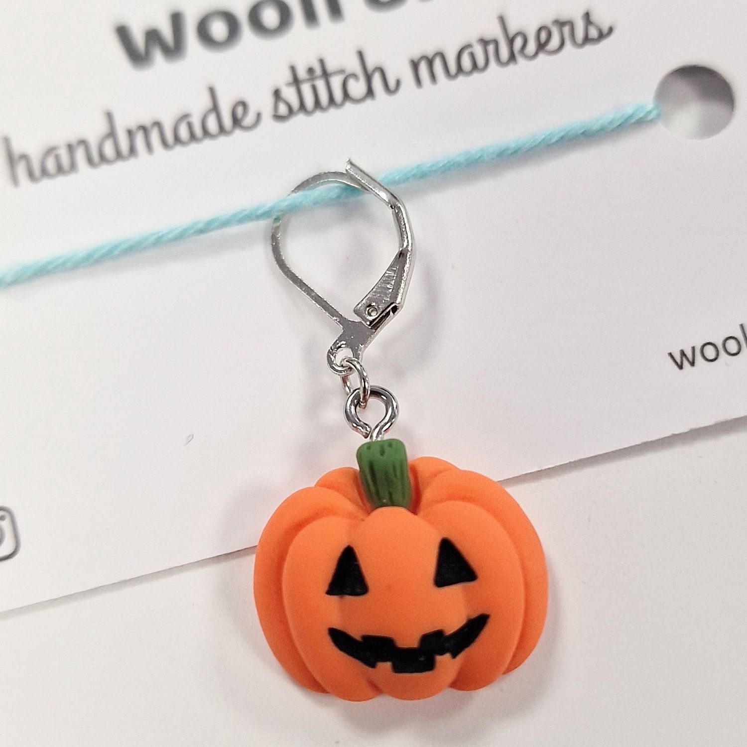 A pumpkin shaped stitch marker.