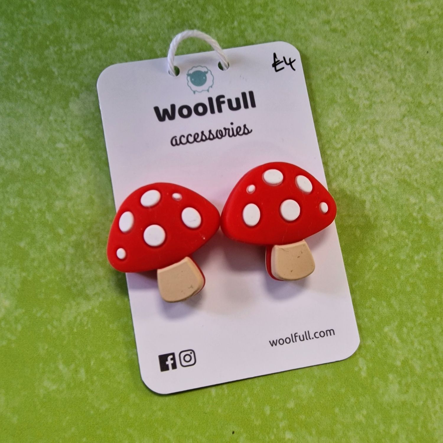 A green background with a pair of mushroom shaped point protectors mounted on a white card.